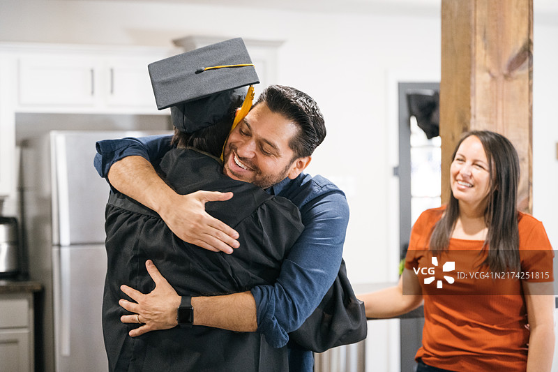 毕业典礼上拥抱儿子的自豪父亲图片素材