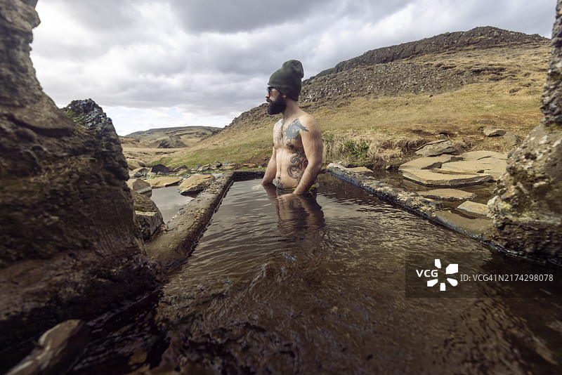 男游客在冰岛Hrunalaug温泉池中放松身心图片素材