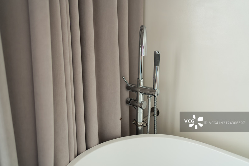 房间里的白色浴缸和旁边的椅子图片素材