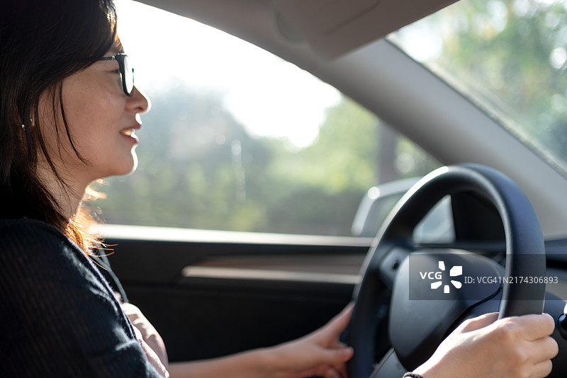 一位亚洲女性微笑着驾驶电动车图片素材