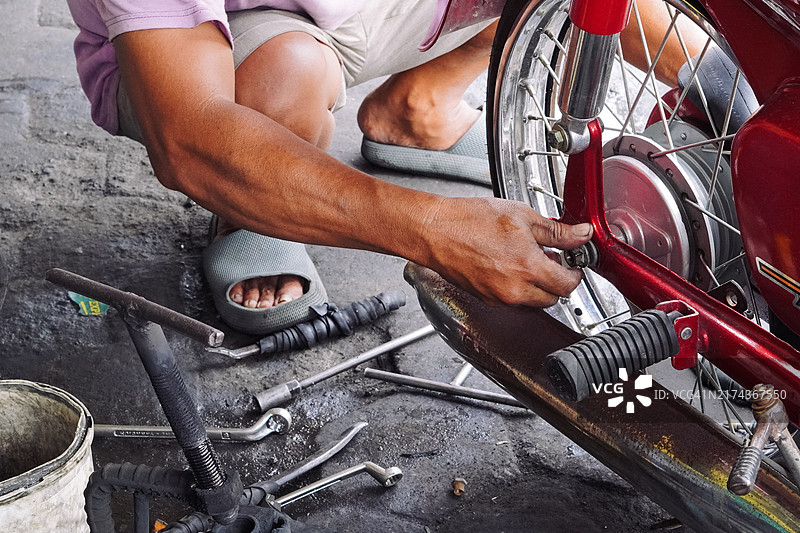 修理店里，技工正在给摩托车安装车轮图片素材