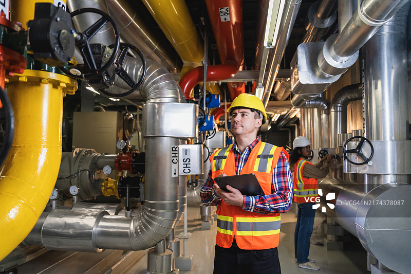 石油天然气炼油生产。工人在燃气管道旁检查分配和消耗图片素材