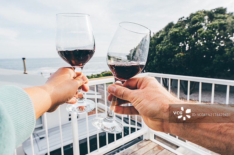 一对情侣在阳台上享受海景饮品，享受假期。图片素材