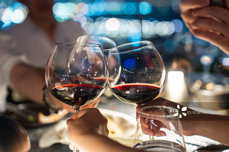 屋顶酒吧夜晚，白色葡萄酒杯在模糊的散景照明下的特写镜头图片素材