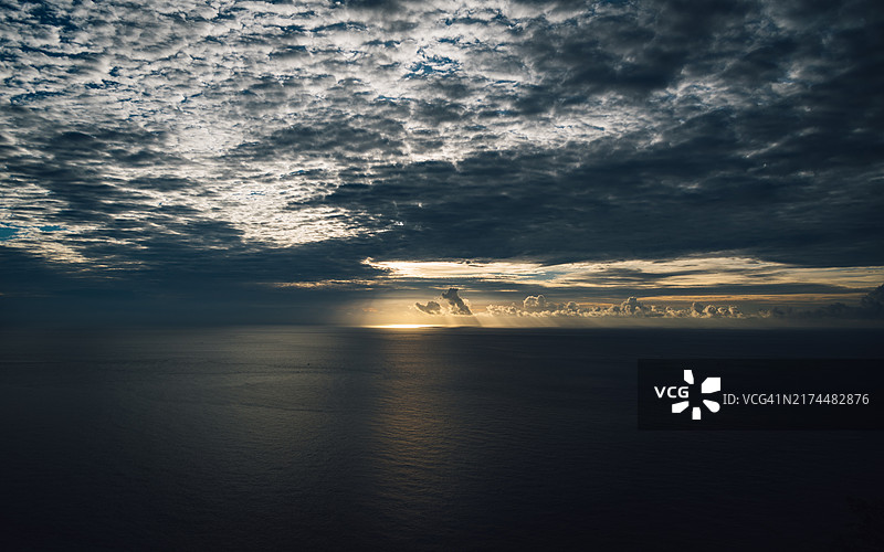 太平洋日出，远处云彩和橙黄色调映照在海面上图片素材