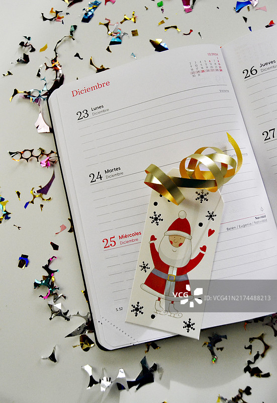 圣诞节打开的日程本，桌子上装饰着彩色纸屑图片素材