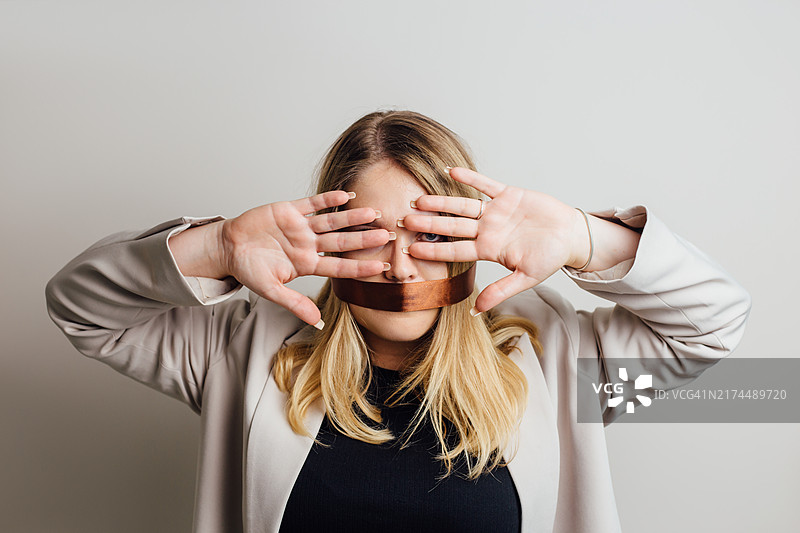捂着脸的被塞住嘴的女人肖像图片素材