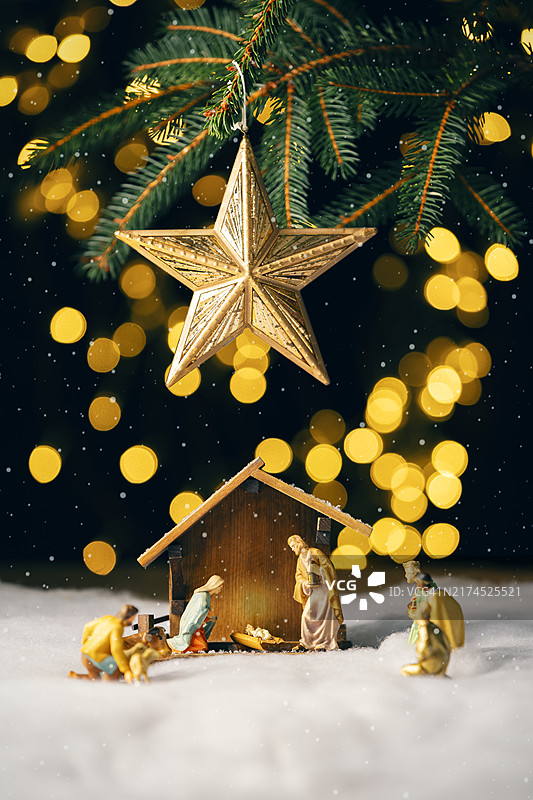圣诞树下暴风雪中的复古耶稣诞生场景图片素材
