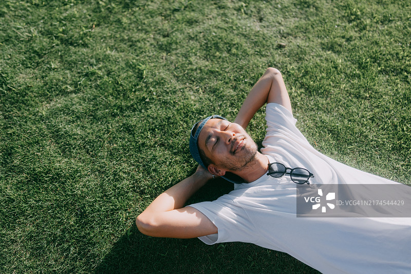 男子夏天躺在草地上图片素材
