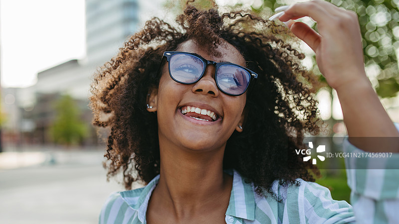 戴眼镜的年轻女子都市写真，抓拍镜头图片素材