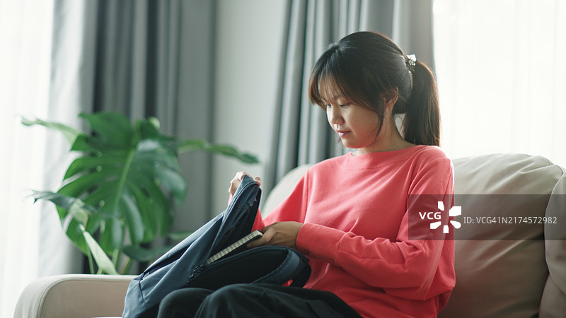 女孩把书装进包里图片素材