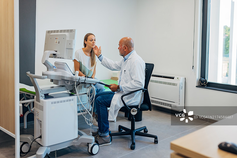 治疗师正在检查一位抱怨喉咙痛的女性患者图片素材