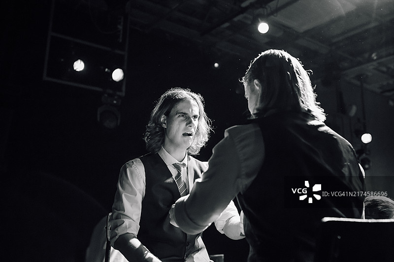 魅力四射的演员身着老式西装，手持假枪，在业余戏剧表演中巧妙地展现了激烈的竞争图片素材