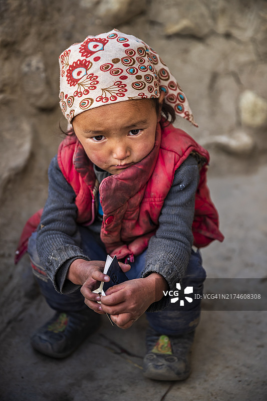 藏族小女孩站在她父母的房子旁边，尼泊尔上木斯塘图片素材