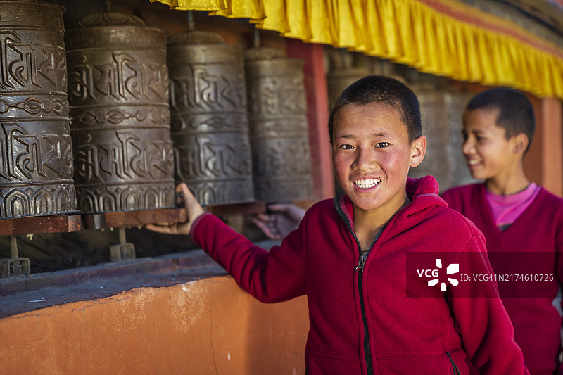 藏族聚居区新手僧侣转动祈祷轮，尼泊尔上木斯塘宗朗村图片素材