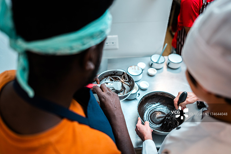 学生在面包店厨房与厨师一起制作蛋糕图片素材