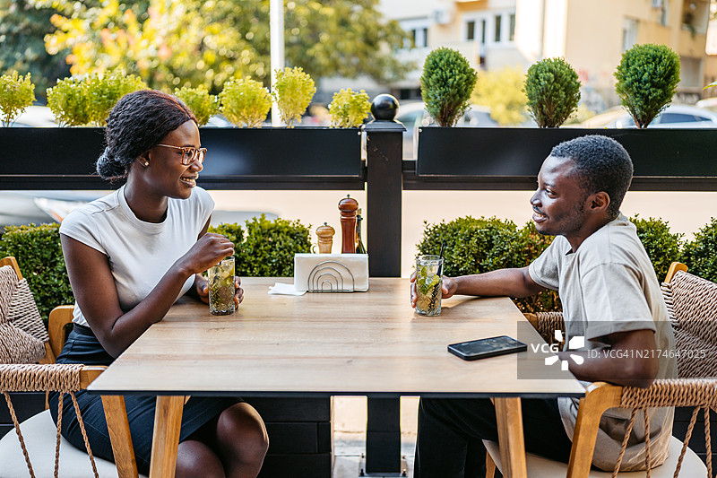 在户外酒吧喝莫吉托鸡尾酒的年轻黑人情侣图片素材