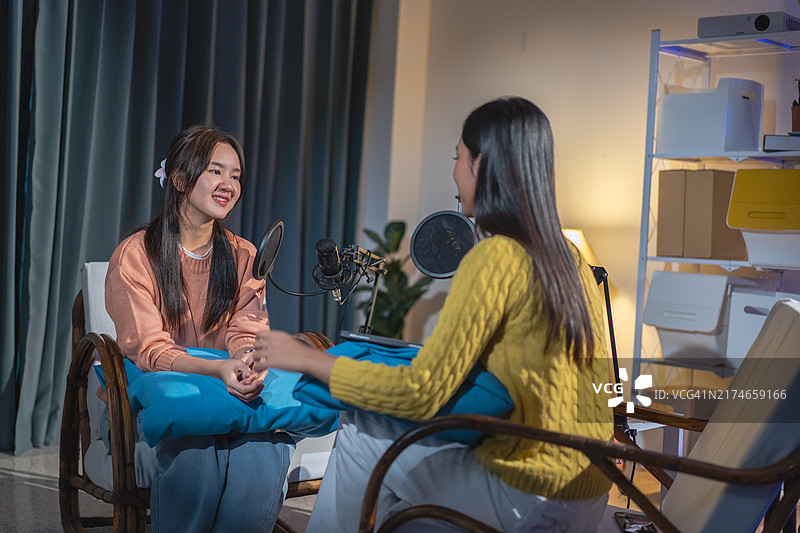 两位亚洲女性在播客节目中进行有趣的对话图片素材