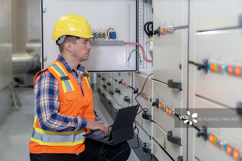 电气工程师检查建筑控制室内的开关柜图片素材