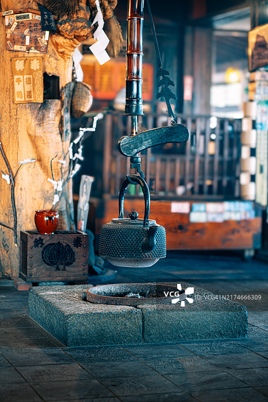 传统日式铁壶悬挂在火炉上图片素材