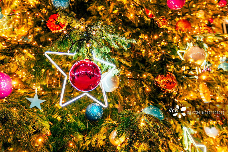 彩色照明圣诞树上的圣诞装饰品特写图片素材