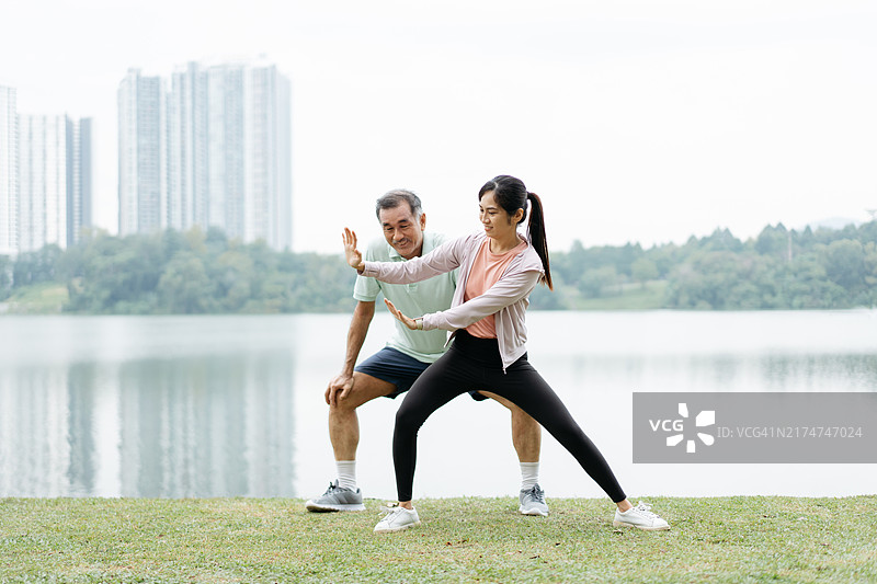 亚洲父亲和女儿在公园里练习太极拳图片素材