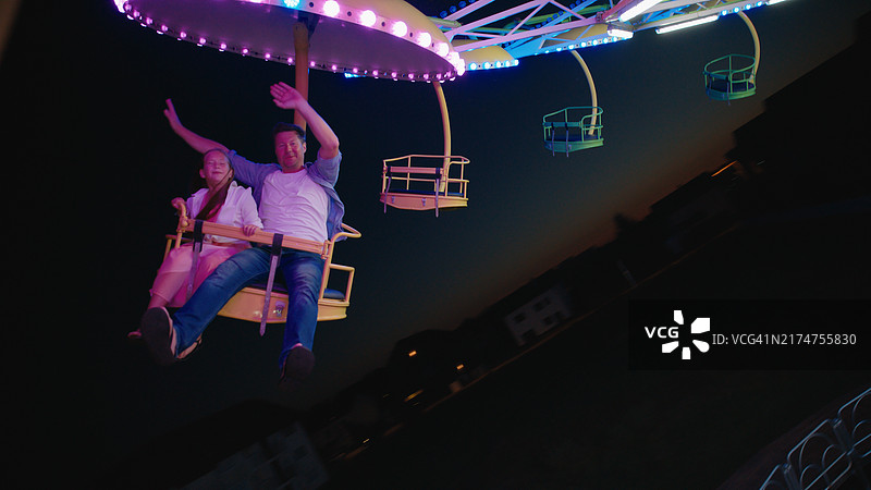 快乐的白人父女玩旋转秋千图片素材