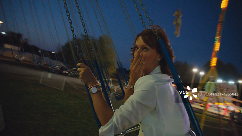 白人女性享受夜间旋转木马图片素材