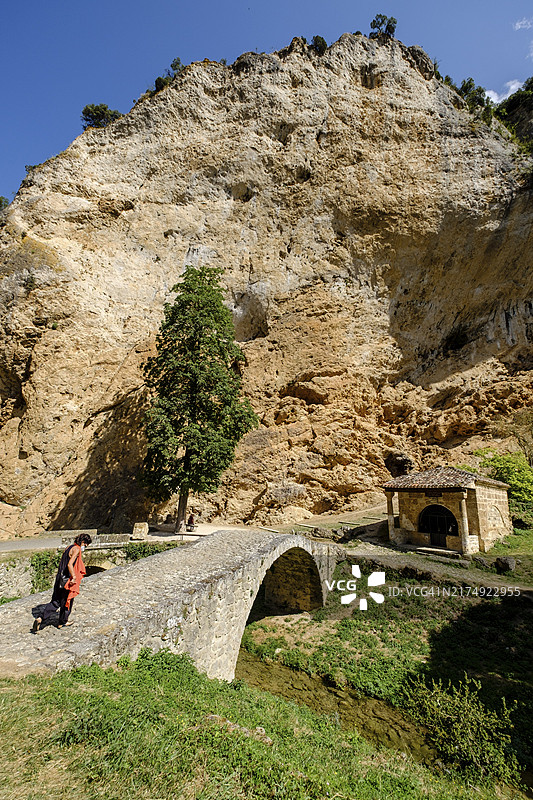 走过桥的女人，圣玛丽亚德拉奥兹中世纪隐修院，托贝拉，弗里亚斯市的城镇，卡斯蒂利亚和莱昂自治区，西班牙，欧洲图片素材