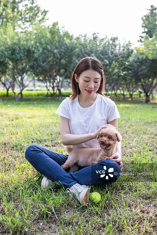在公园里遛狗的漂亮亚洲女人图片素材