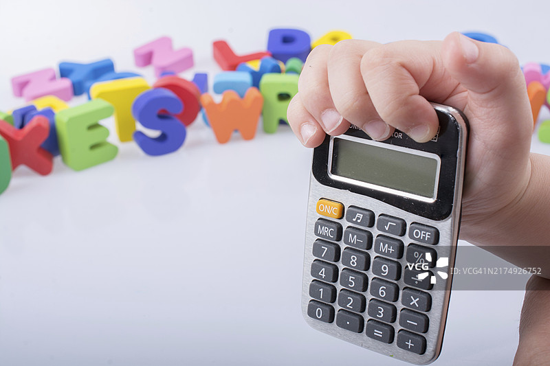 手持小计算器，白色背景上带有彩色字母图片素材
