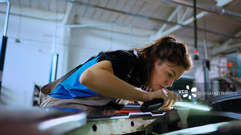 修理工使用照明灯检查车内图片素材