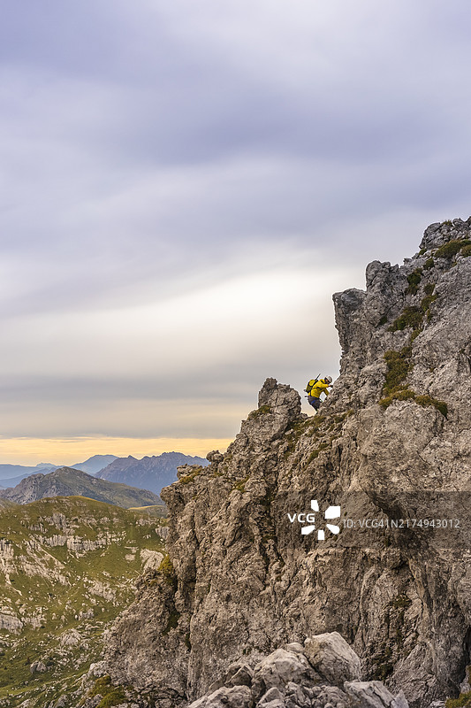 日落时分攀登岩石峭壁的冒险者图片素材