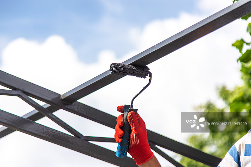 男人粉刷金属杆（选择性焦点）图片素材