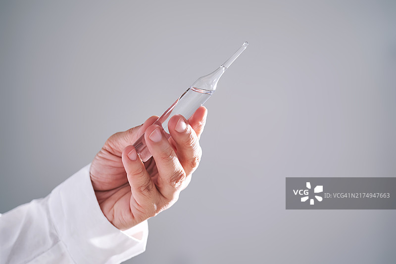 医生手持装有药物的安瓿瓶特写图片素材