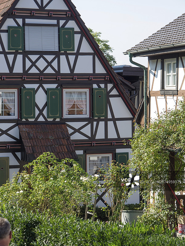 德国弗罗伊登施塔特带绿色百叶窗和花园的半木结构房屋图片素材