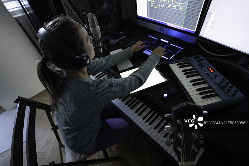 在音乐工作室里用MIDI鼓垫控制器演奏的女人（特写）图片素材