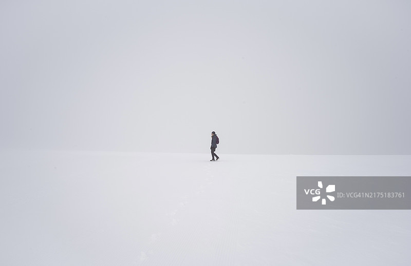 德国黑森林费尔德贝格，雪景中被白雾环绕的孤独女人。图片素材