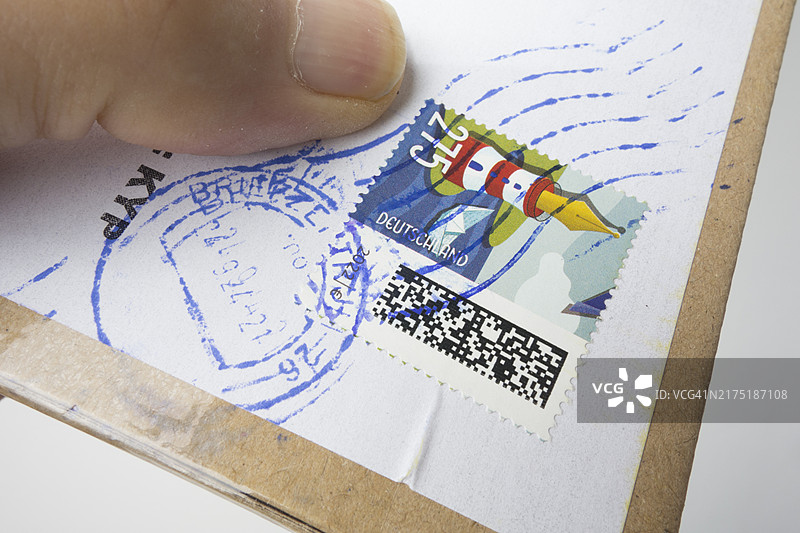 拿着贴有德国邮票的信件的人图片素材