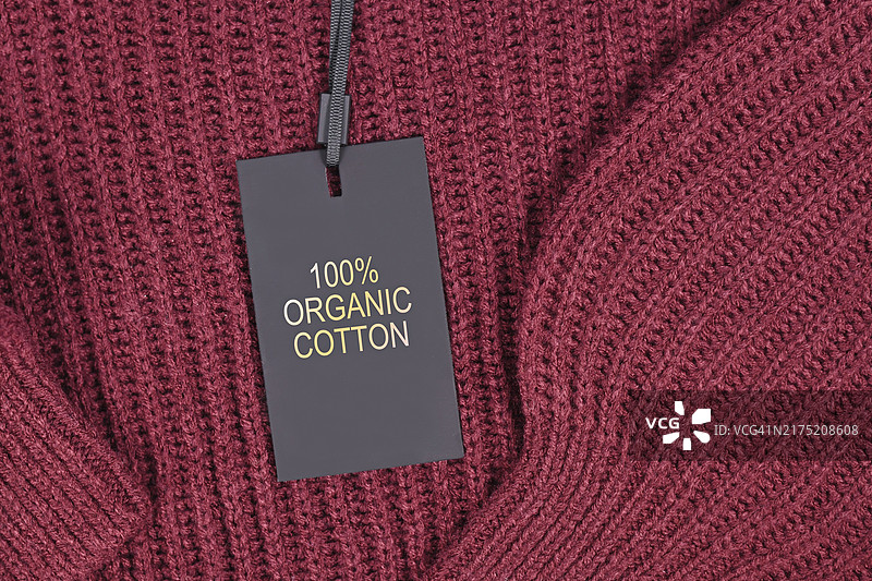 环保生产的套头衫上附有“100%有机棉”标签图片素材