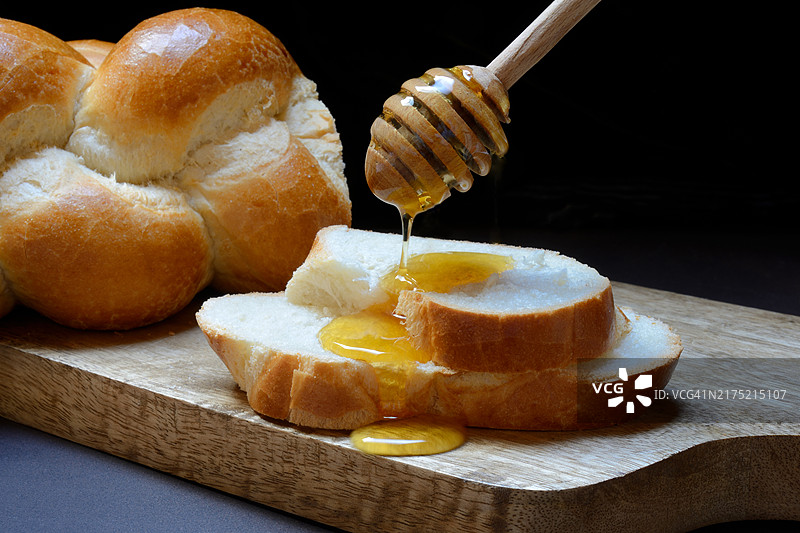 滴在黄油辫子圆盘上的蜜蜂蜂蜜图片素材