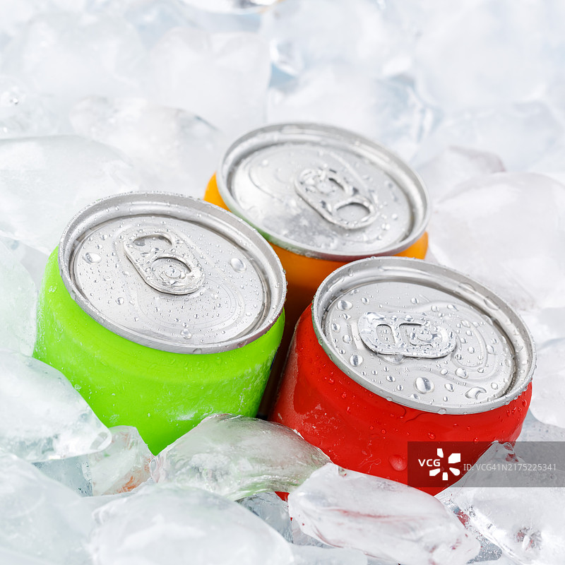 罐装饮品：柠檬水、可乐和软饮，在冰块上图片素材