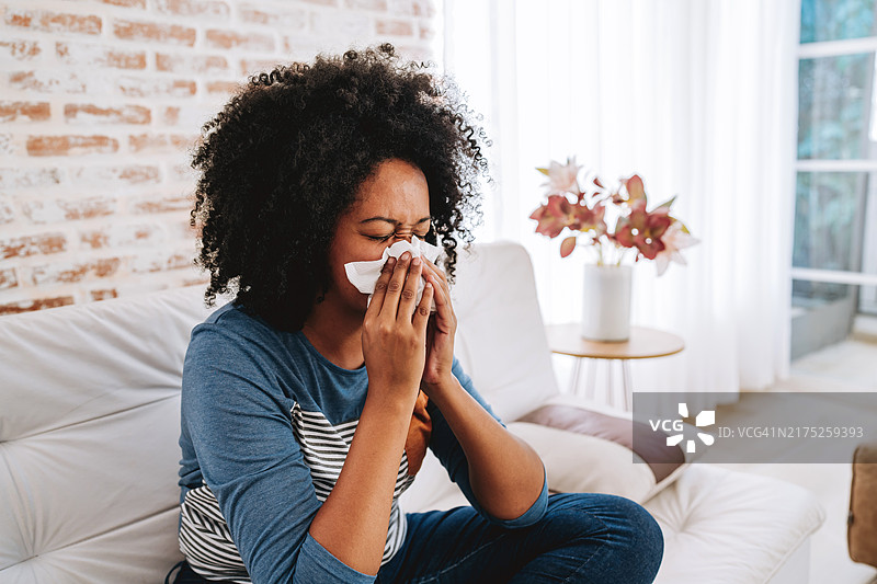 用纸巾捂住鼻子打喷嚏的女人图片素材