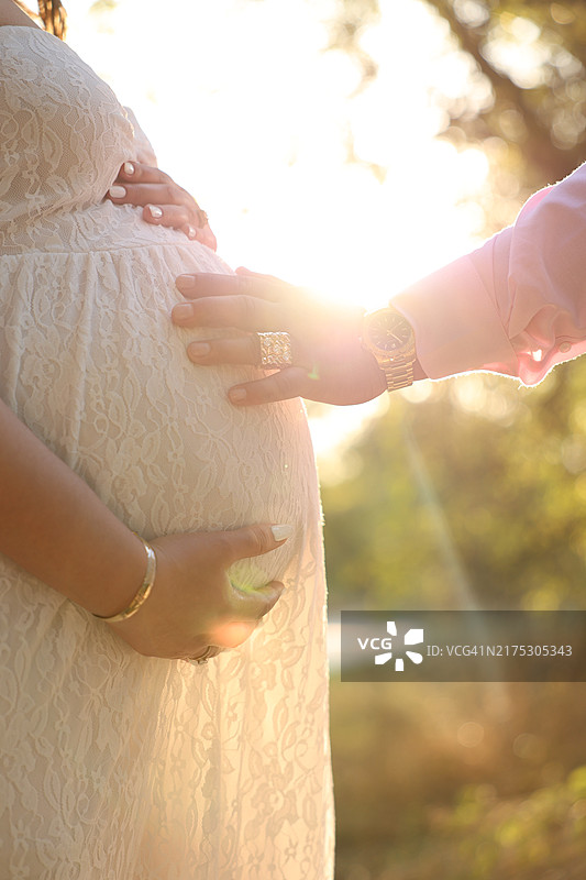 孕妇触摸腹部的腰部特写，美国德克萨斯州奥斯汀图片素材