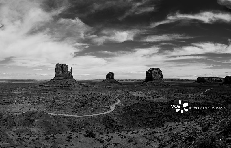 亚利桑那州纪念碑谷部落公园的黑白纪念碑谷部落公园，在戏剧性的天空下，有梅里克孤丘和东西手套图片素材