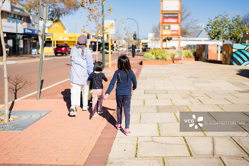 一群人走在人行道和人行横道上的照片图片素材