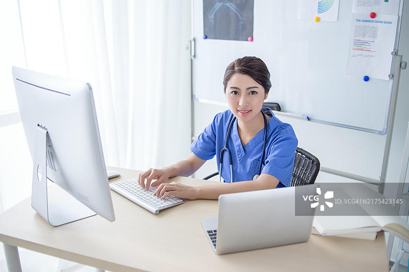 自信的女医生在她的办公室里用电脑工作图片素材