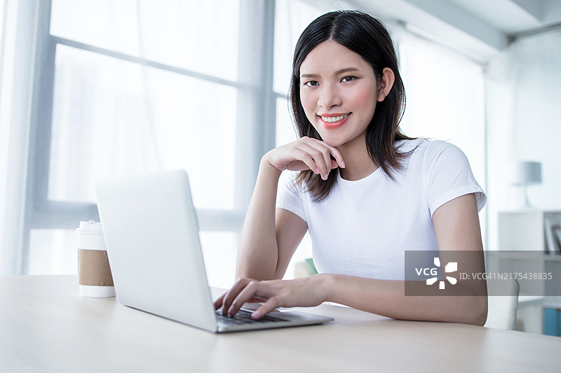 学生在家使用笔记本电脑在线学习并做笔记图片素材