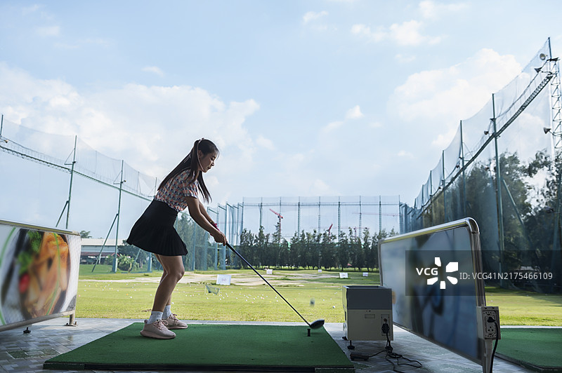 打高尔夫球的美丽女人，亚洲女性在高尔夫球场挥杆图片素材