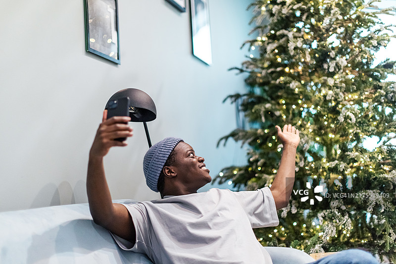 通过视频电话和朋友庆祝圣诞节的黑人男子图片素材